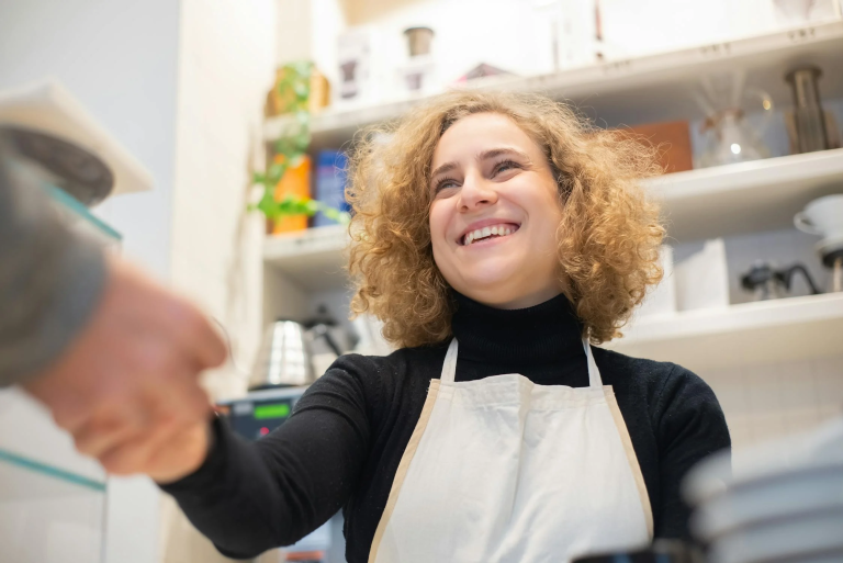 woman in white apron shaking hands
