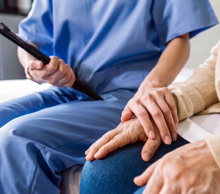 Close-up senior Asian woman hand with her caregiver helping hands, Caregiver visit at home. Home health care and nursing home concept.